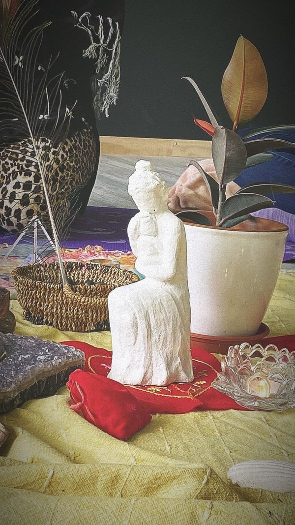 Altar con una figura de madre, una planta y velas en un encuentro